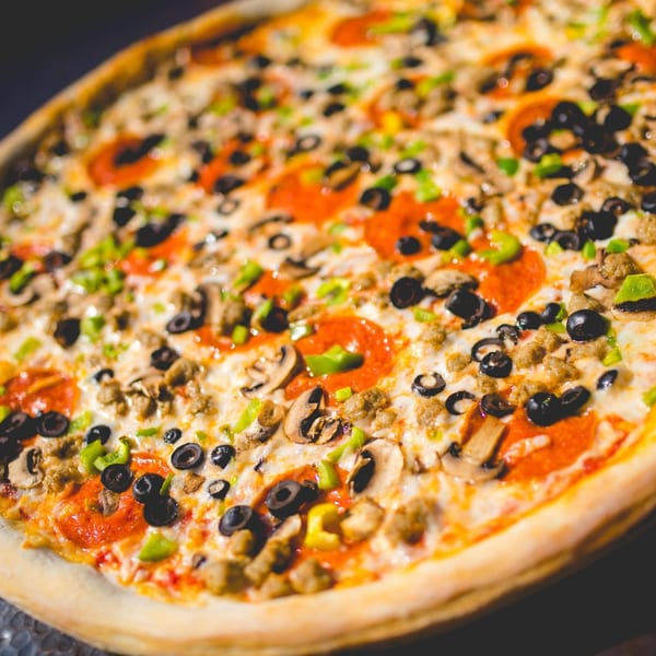 A large, hot Italia Express pizza with pepperoni, sausage, mushrooms, green peppers, and black olives.