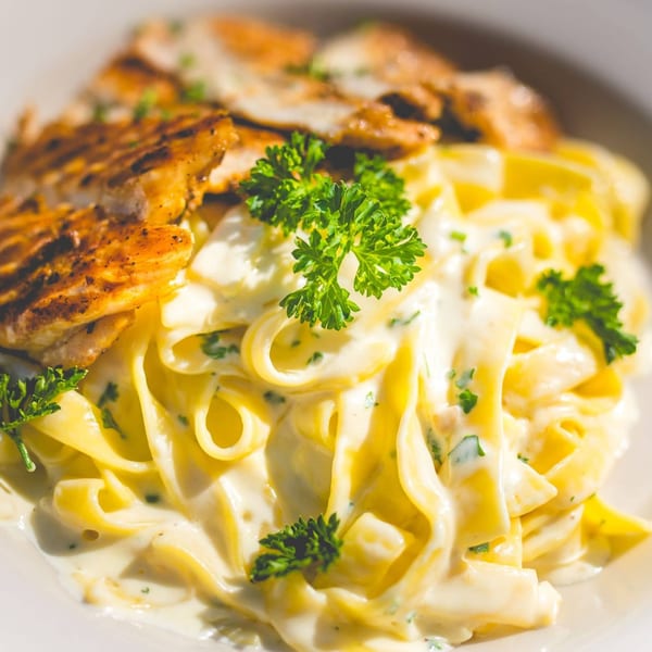 Creamy fettuccine alfredo with grilled chicken and fresh parsley from Italia Express.